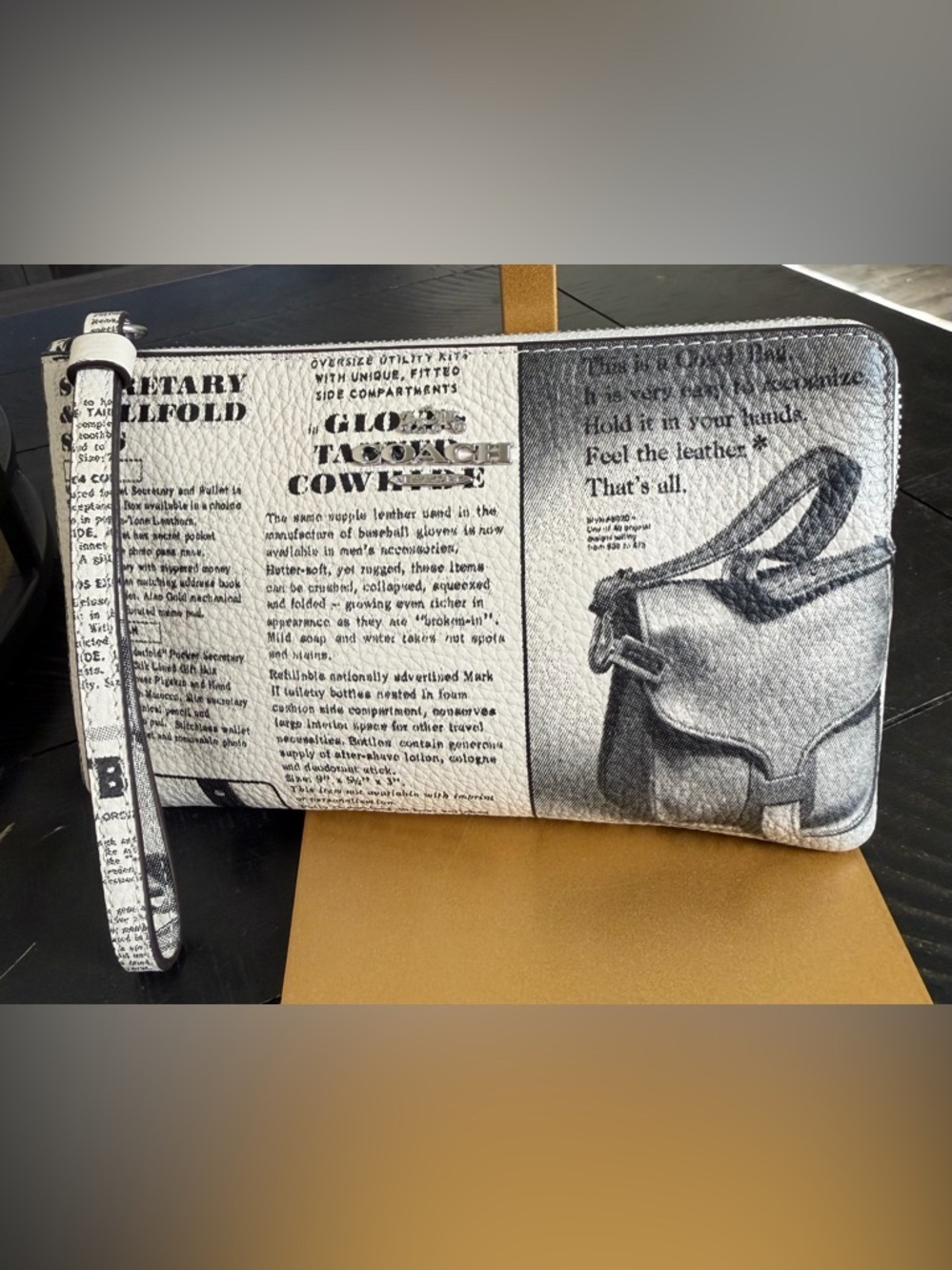 NWT Coach corner zip large pebbled leather wristlet in a newspaper print